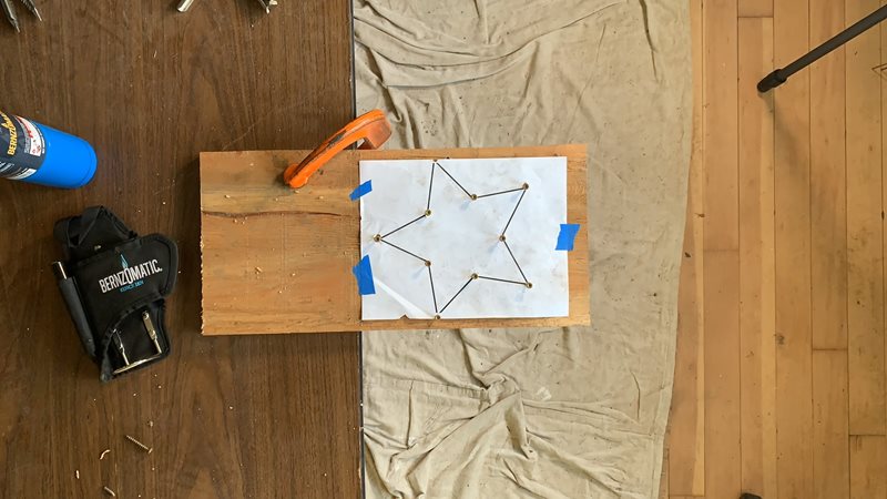 DIY HOLIDAY DECOR Instructions - Step 1 and 2. Clamp your plywood onto your worktable or bench. Tape the star template (or draw your own) onto the plywood.
